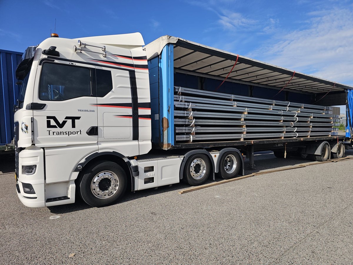 LVT truck with an open curtain trailer carrying metal goods